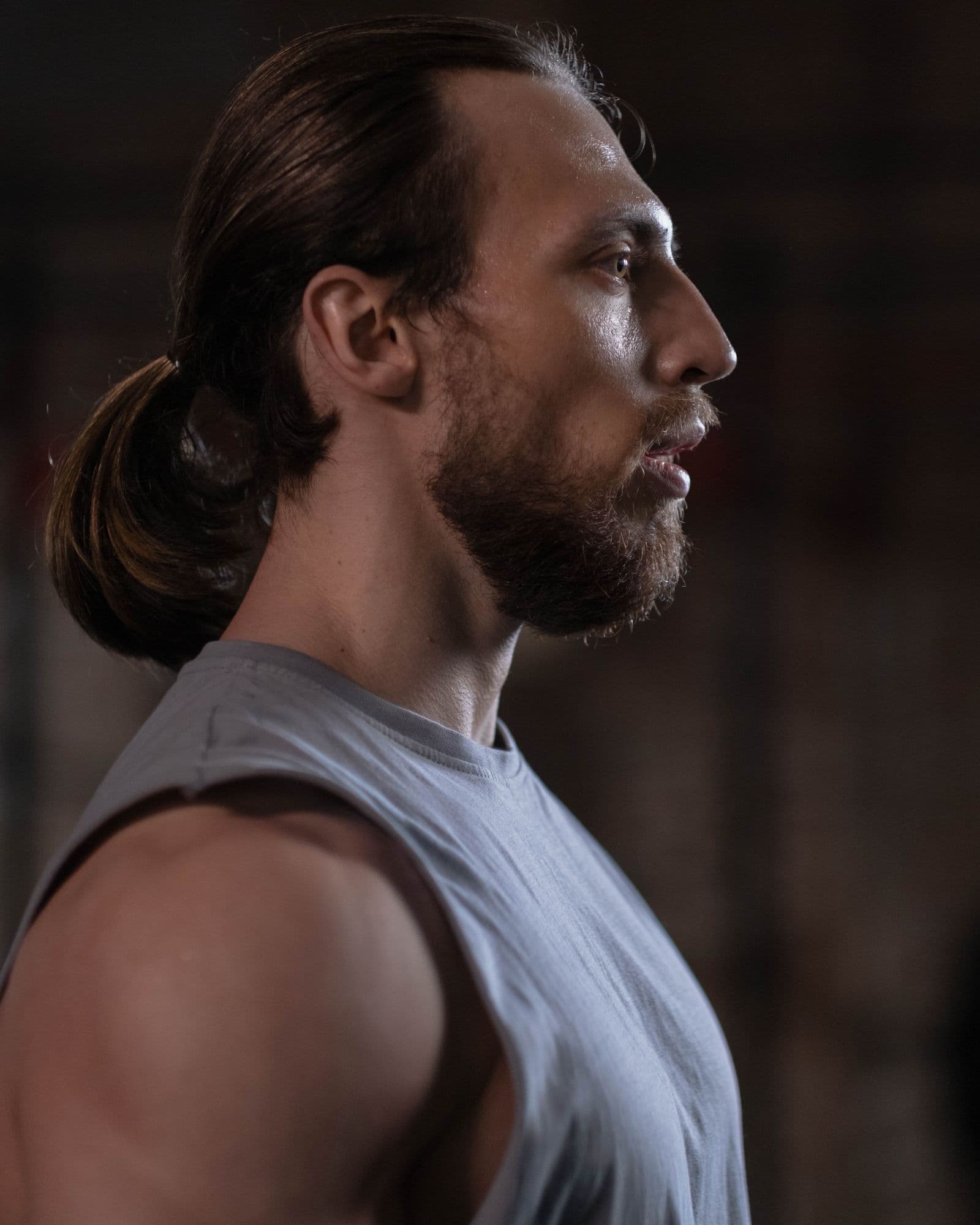 Side profile of an athlete in a sleeveless top, jaw and shoulder in view.